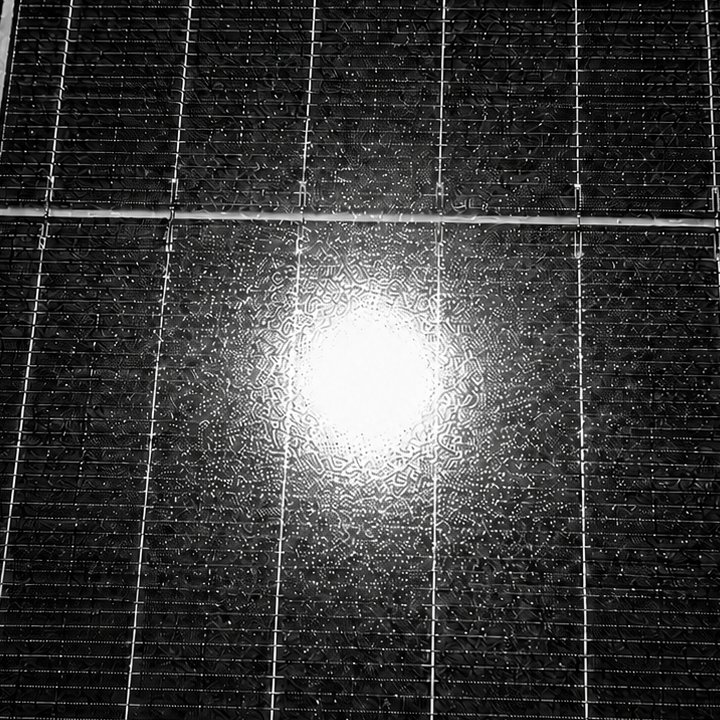 Close-up of a sun reflection on a PV module with an almost round bright core